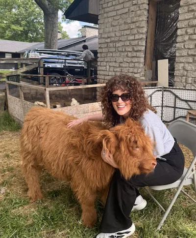 Tamera's daughter with a Scottish Highland cow at True South Farm, Columbia, TN.