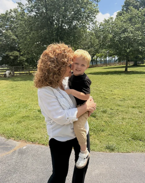 Tamera holding her grandson at True South Farms, 2026.