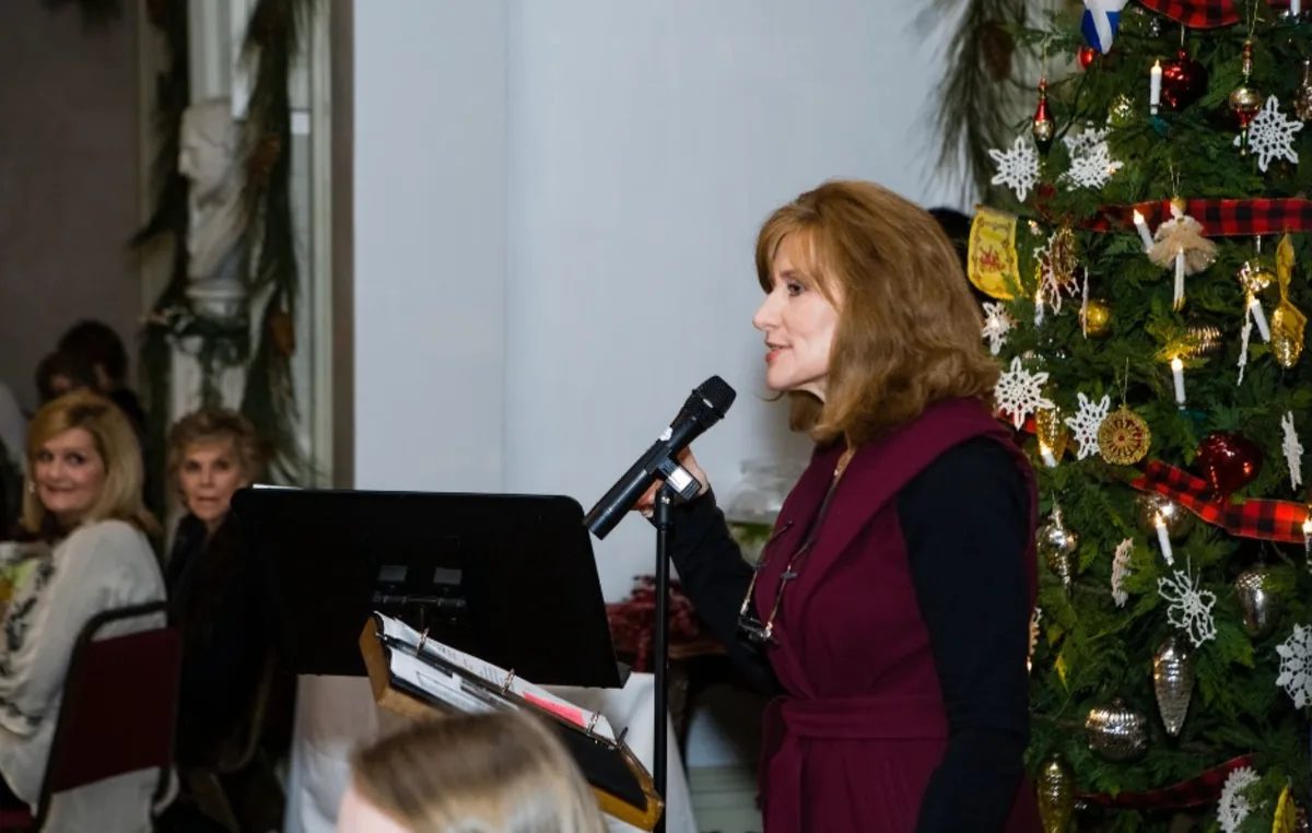 Tamera Alexander speaking near a decorated Christmas tree during the Southern Mansion Reader Weekend