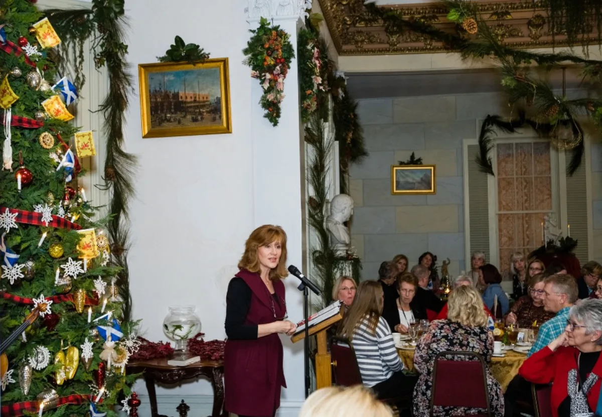 Tamera Alexander speaking to guests during a holiday dinner at the Southern Mansion Reader Weekend