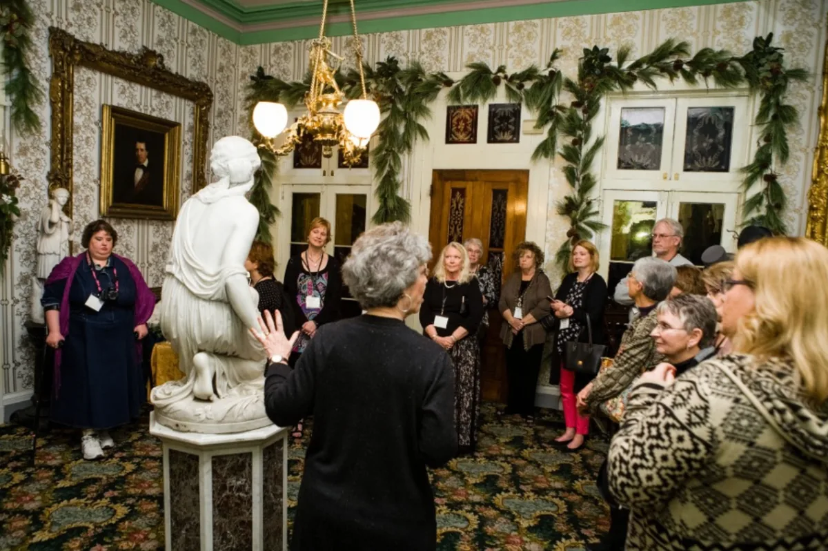 Southern Mansion Reader Weekend guests gathered for a mansion tour in an ornate parlor