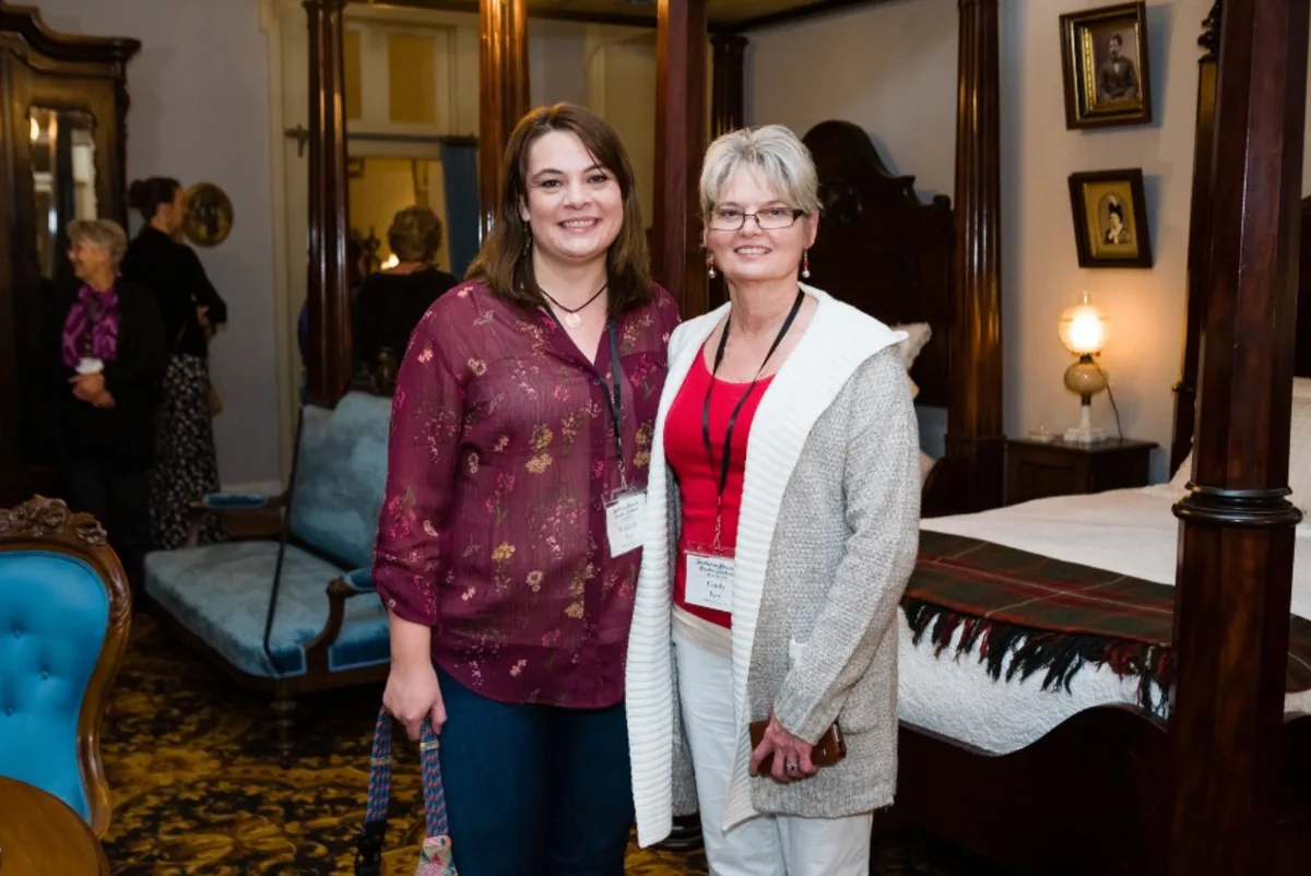 Two Southern Mansion Reader Weekend guests posing together in a historic bedroom