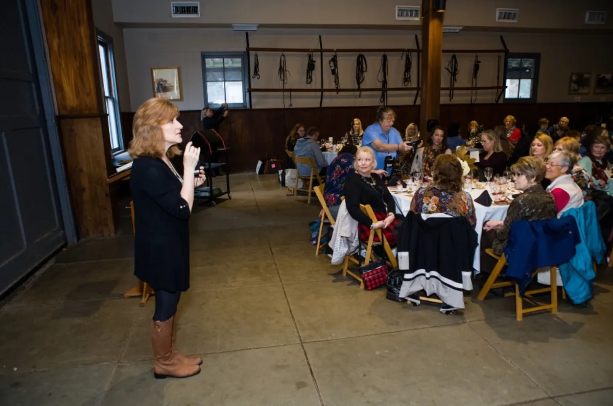 Tamera Alexander speaking to seated guests during a Southern Mansion Reader Weekend meal