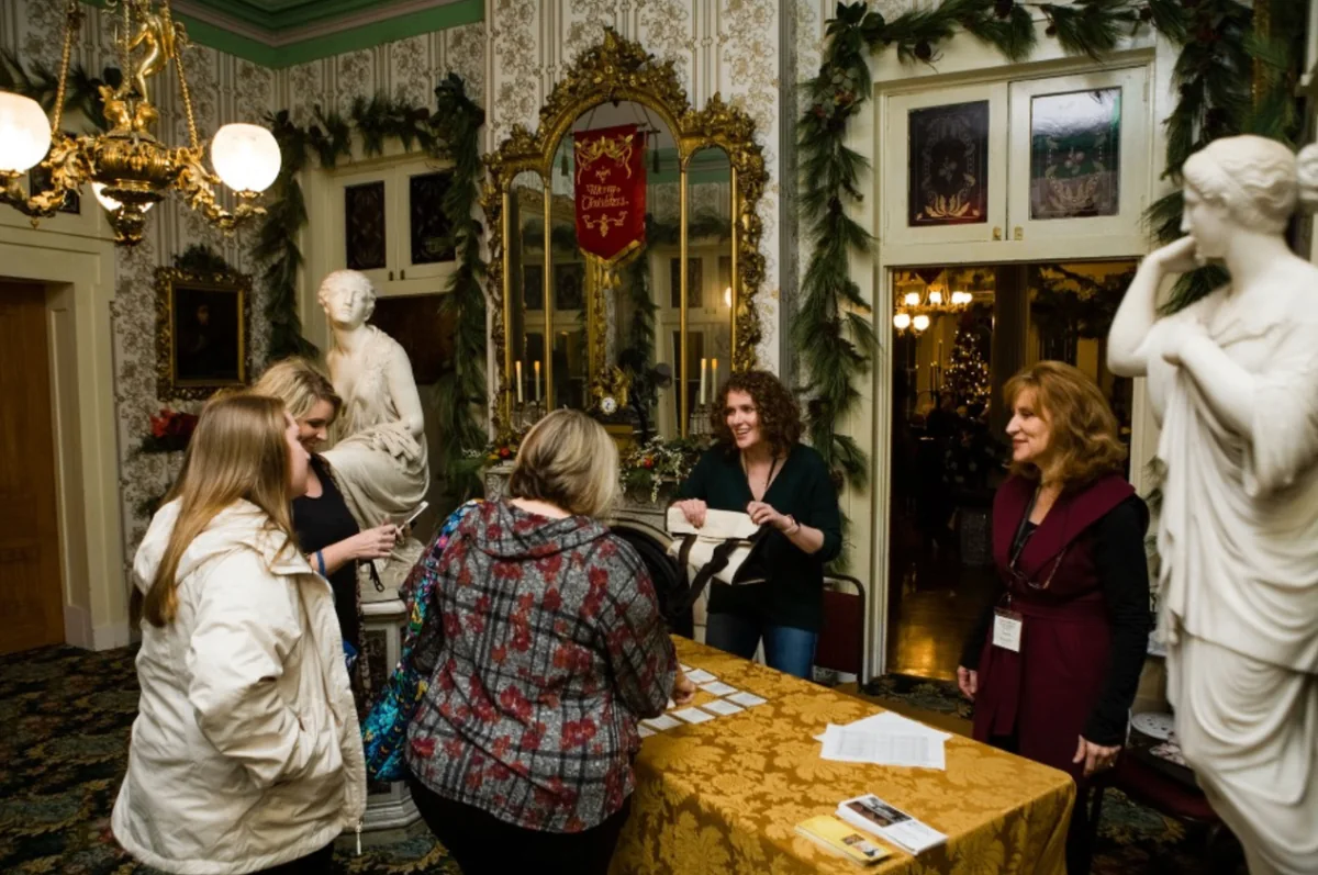 Reader Weekend guests gathering at the Belmont Mansion welcome table