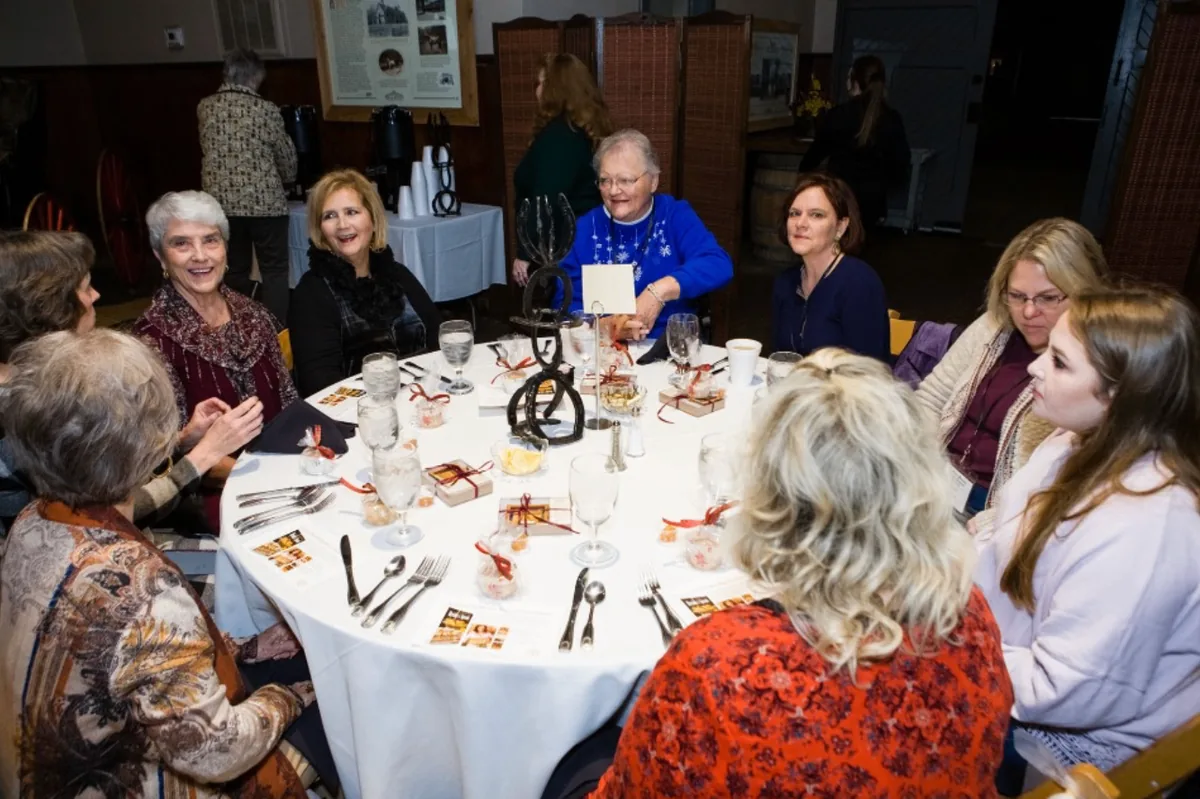 Southern Mansion Reader Weekend attendees gathered for dinner around a decorated round table