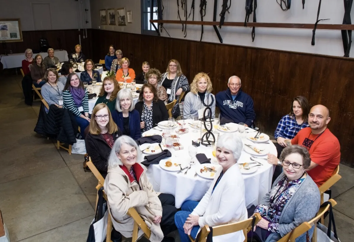 Southern Mansion Reader Weekend guests seated together around a round dinner table