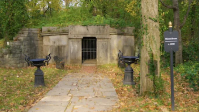 The old Belle Meade family mausoleum surrounded by woods and stone urns.