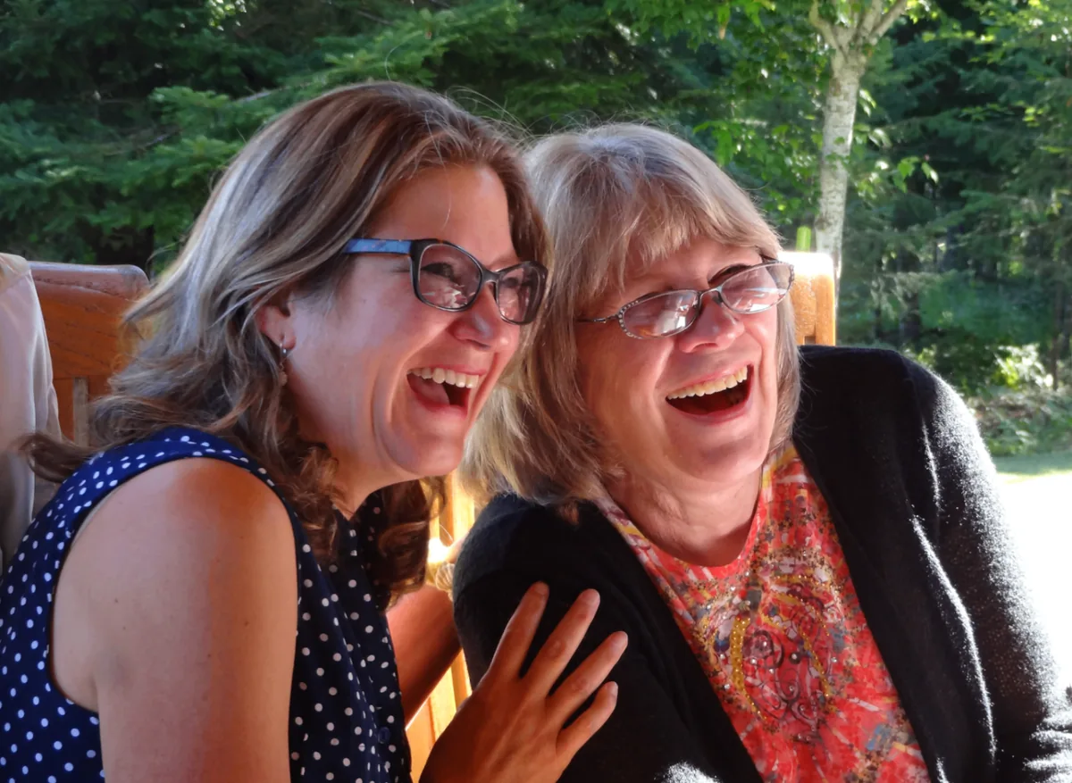 Two Coeur d'Alene Sisters laughing together on the retreat porch.