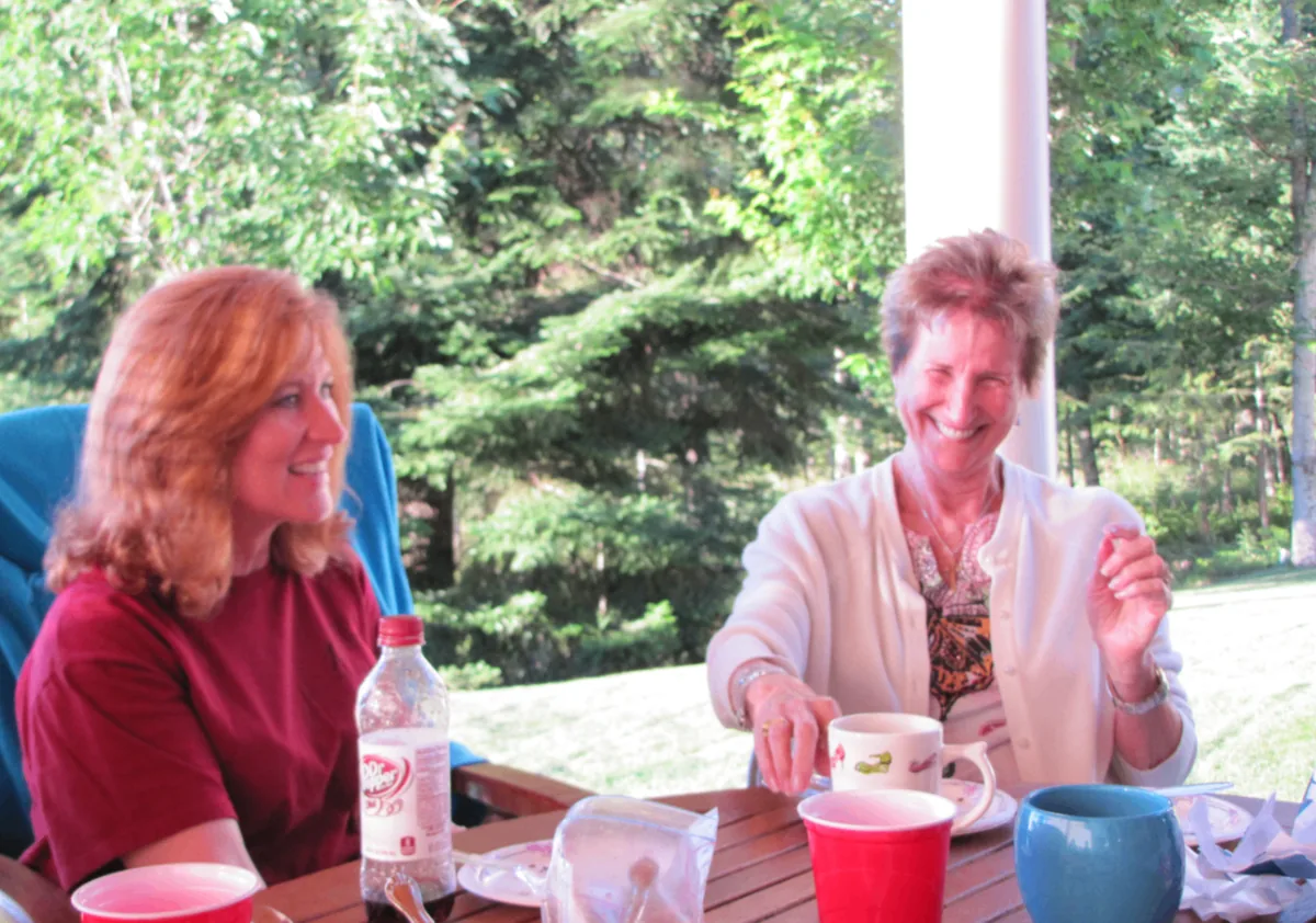 Two Coeur d'Alene Sisters visiting together outdoors at the retreat.