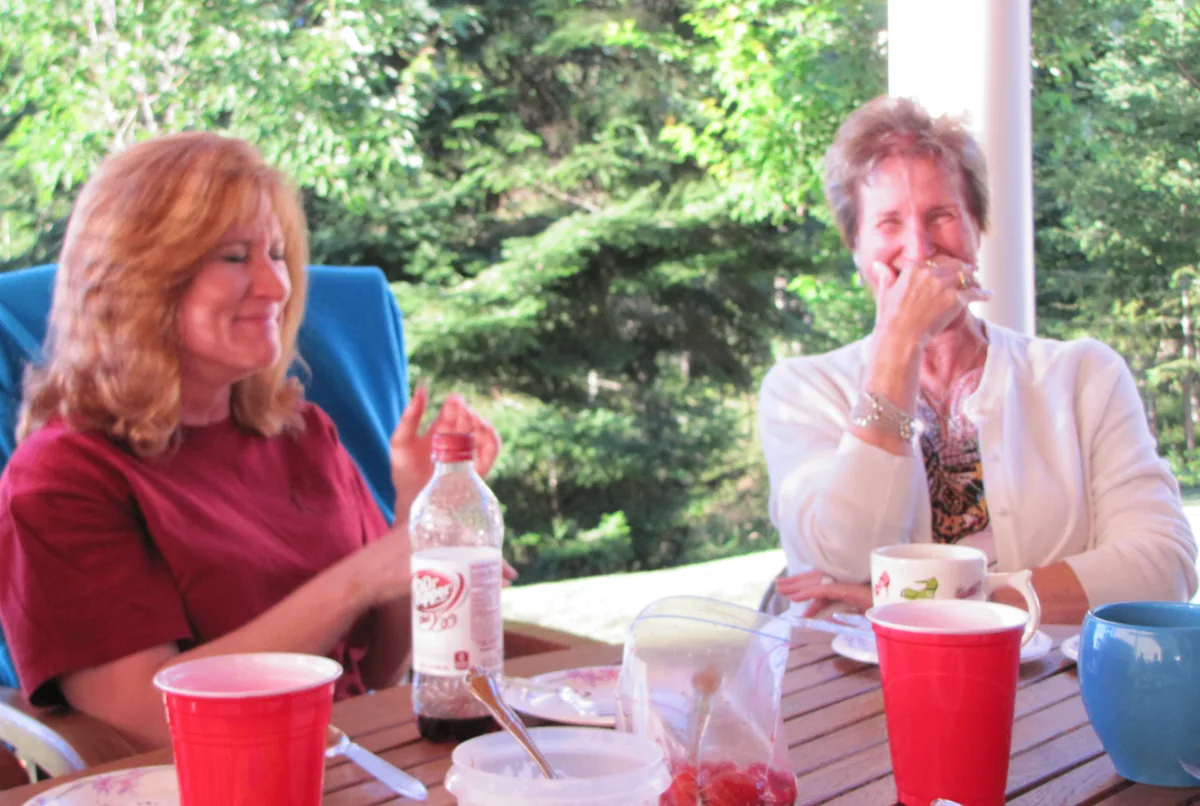 Two Coeur d'Alene Sisters sharing a laugh at the retreat table.