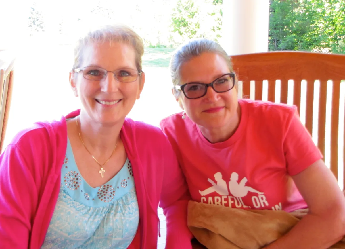 Two Coeur d'Alene Sisters smiling together on the retreat porch.